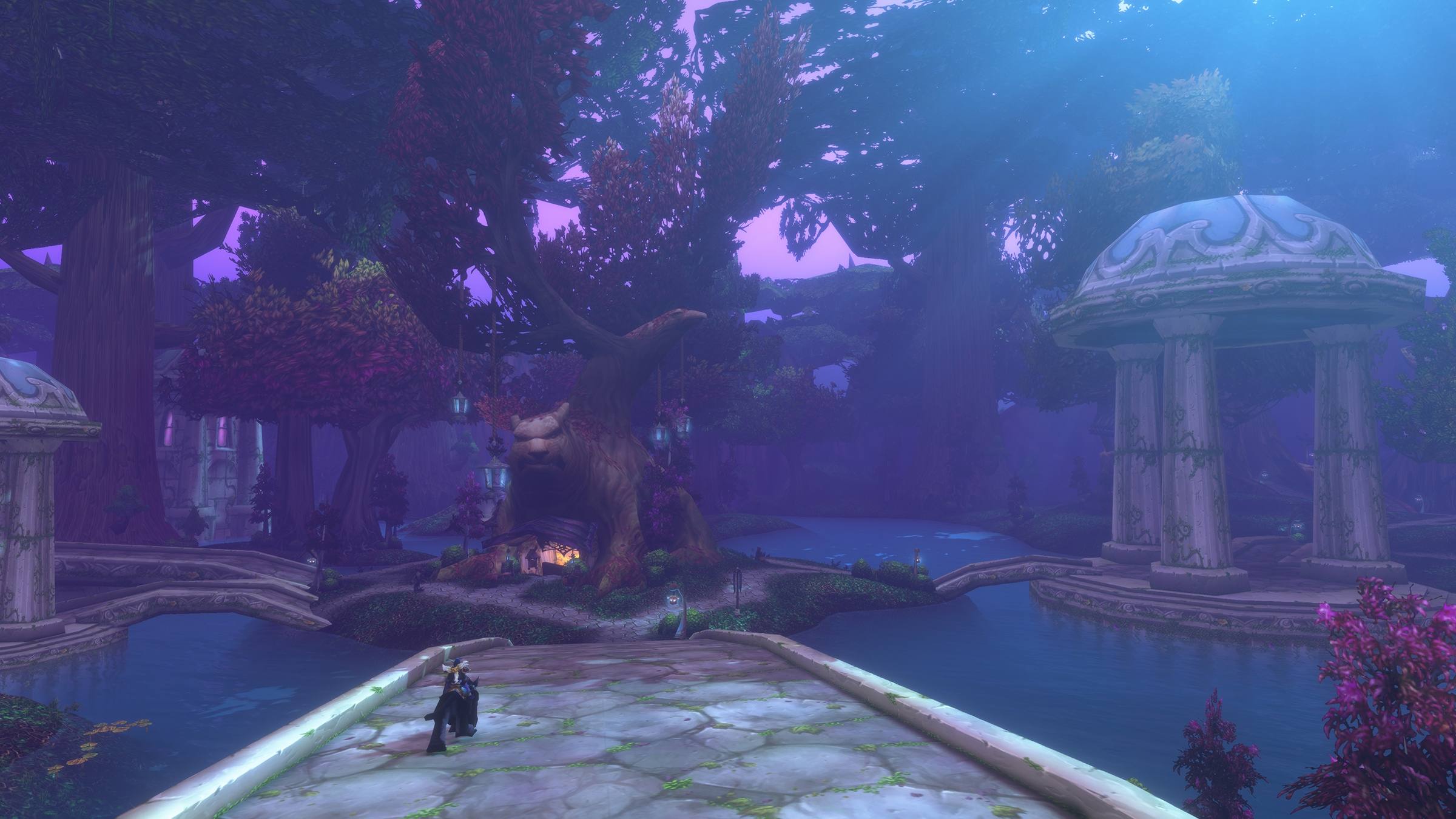 Darnassus de noche: templetes de piedra, agua y árboles con luz violeta.